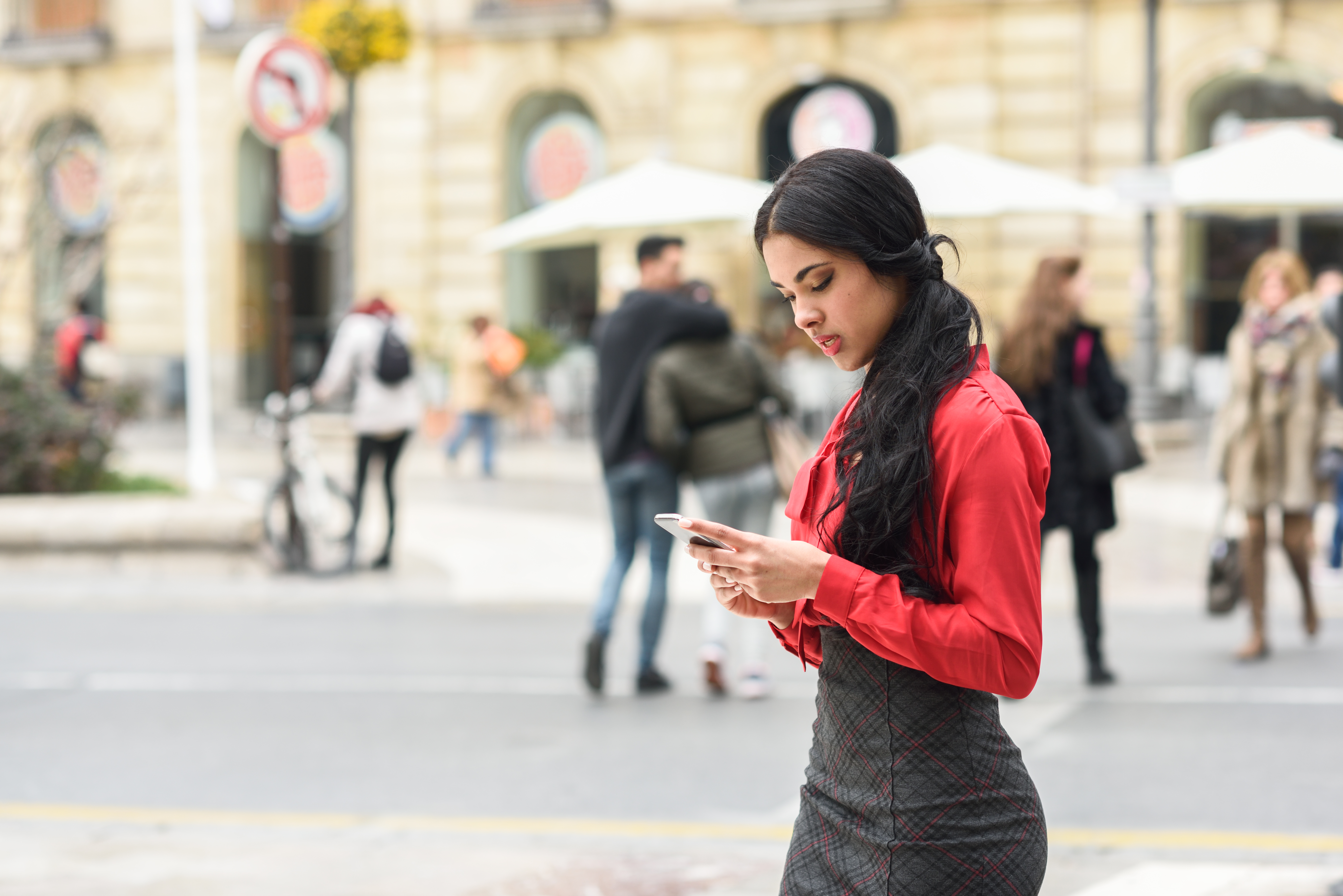 young-businesswoman-texting-street